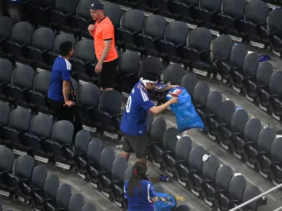 Japan fans clean up trash in the stadium following the World Cup Group F soccer match between the Netherlands and Japan in Arlington, Texas, near Dallas, Sunday, June 14, 2026. (AP Photo/Jessica Tobias)