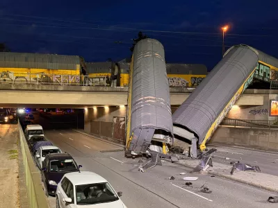 Two cars of a freight train which derailed after a collision, fell off a bridge and lay on a road in Munich, Germany, June 20, 2026.  REUTERS/Christine Uyanik
