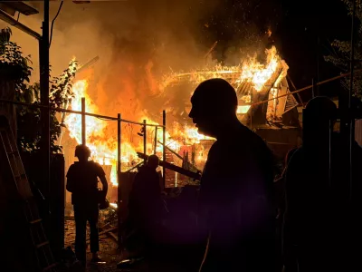 Residents look at a private house that burns after an overnight Russian drone strike, amid Russia's attack on Ukraine, in Zaporizhzhia, Ukraine June 22, 2026. Picture taken with a mobile phone. REUTERS/Serhii Chalyi   TPX IMAGES OF THE DAY