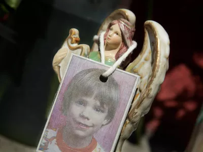 FILE - A photograph of Etan Patz hangs on an angel figurine, as part of a makeshift memorial in New York, May 28, 2012. (AP Photo/Mark Lennihan, File)