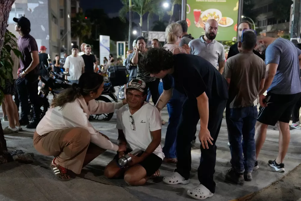 People remain outside their homes after an earthquake in Caracas, Venezuela, Wednesday, June 24, 2026. (AP Photo/Ariana Cubillos)