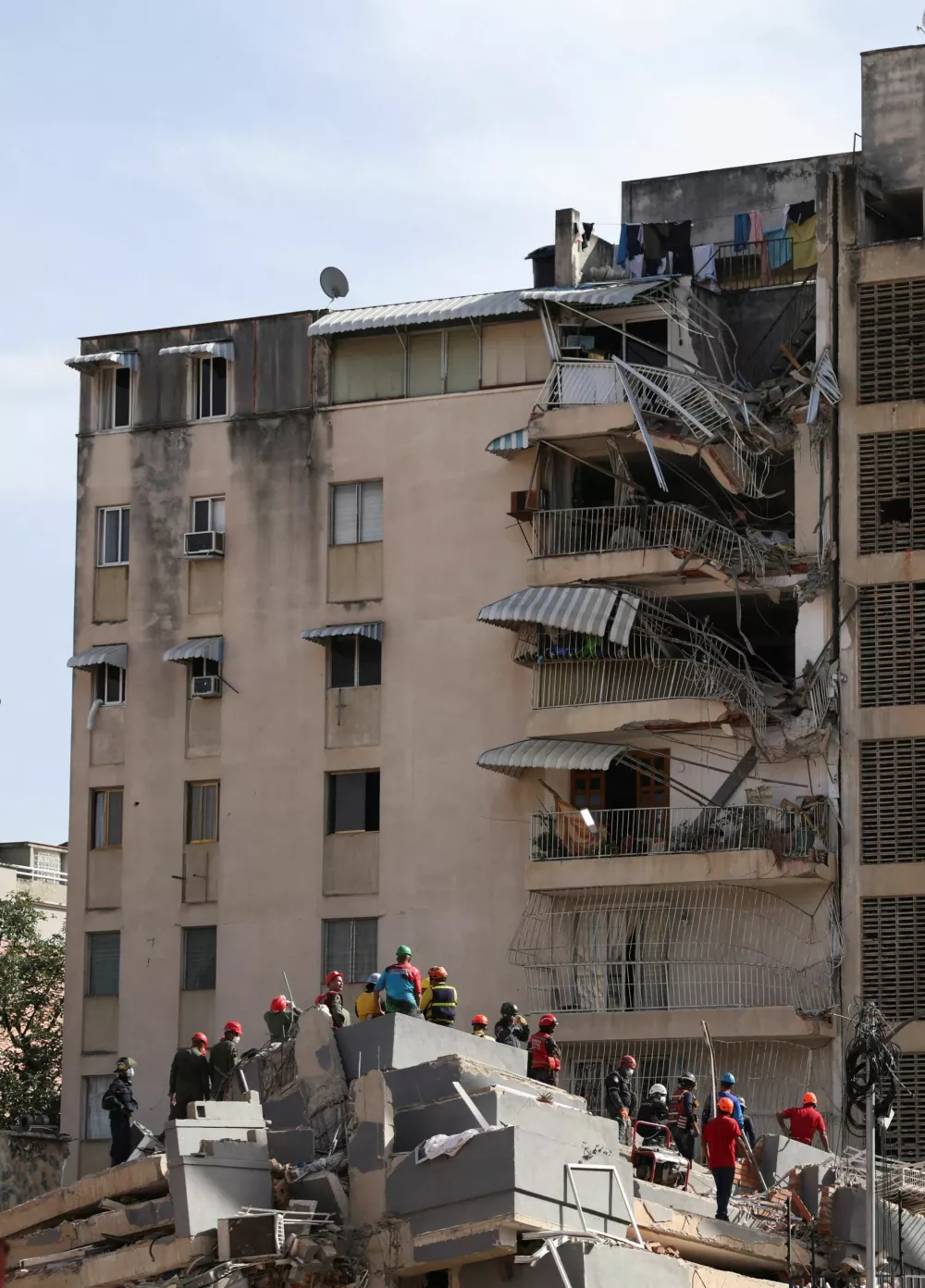 People stand atop the rubble of a collapsed building in the aftermath of earthquakes in Caracas, Venezuela, June 25, 2026. REUTERS/Leonardo Fernandez Viloria