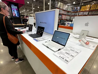 FILE - A shopper looks over Apple MacBook laptops on display in a Costco warehouse on June 2, 2026, in Sheridan, Colo. (AP Photo/David Zalubowski, File)
