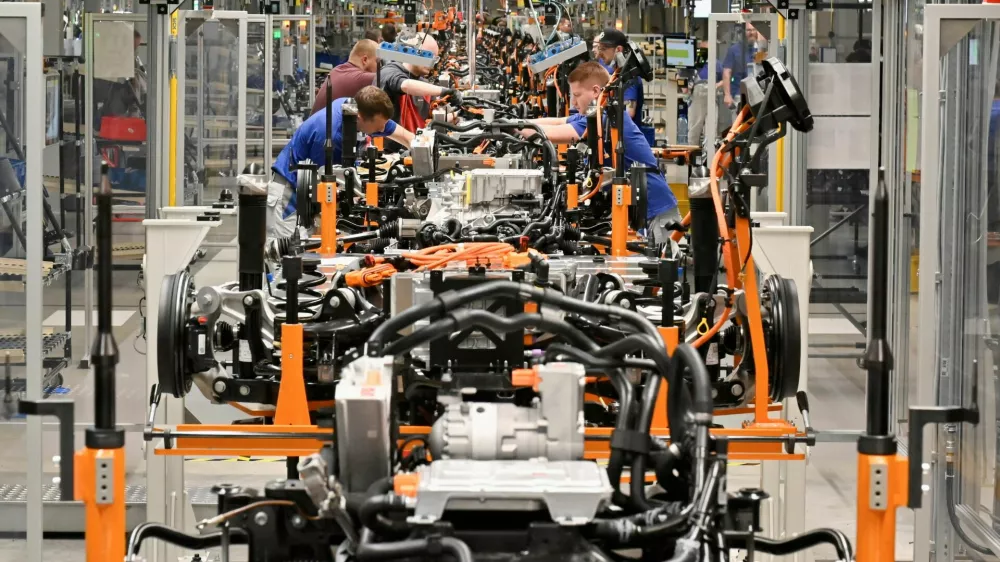 FILE PHOTO: Technicians work at the production line for electric car models of the Volkswagen Group, in Zwickau, Germany, April 26, 2022. REUTERS/Matthias Rietschel/File Photo
