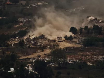 An Israeli tank moves past destroyed buildings in southern Lebanon as seen from northern Israel, Friday, June 26, 2026. (AP Photo/Leo Correa)
