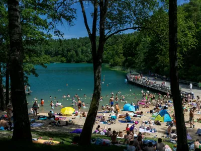 People enjoy a warm weather by a lake near Vilnius, Lithuania, Saturday, June 27, 2026. (AP Photo/Mindaugas Kulbis)
