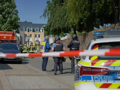08 May 2026, Rhineland-Palatinate, Sinzig: Police officers and police vehicles stand behind barrier tape. According to initial police reports, a hostage situation has occurred at a bank branch in Sinzig, Rhineland-Palatinate. The emergency services are on the scene with a large contingent in the Ahrweiler district. Photo: Sascha Ditscher/dpa - ATTENTION: Civilian person and identification number(s) have been pixelated for legal reasons,Image: 1097317297, License: Rights-managed, Restrictions: GERMANY OUT, Model Release: no