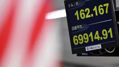 An electronic board shows Japan's benchmark Nikkei 225 index, bottom, and exchange rate of the Japanese yen against the U.S. dollar in Tokyo Tuesday, June 30, 2026. (Kenichiro Kojima/Kyodo News via AP)