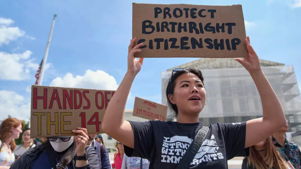 FILE - Hannah Liu, 26, of Washington, holds up a sign in support of birthright citizenship, May 15, 2025, outside of the Supreme Court in Washington. (AP Photo/Jacquelyn Martin, File)