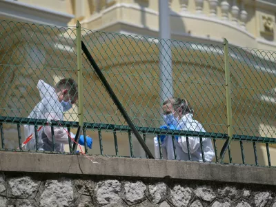 Investigators examine the scene at the residential building where an explosive device seriously injured three people a day earlier in Monaco, Tuesday, June 30, 2026. (AP Photo/Philippe Magoni)