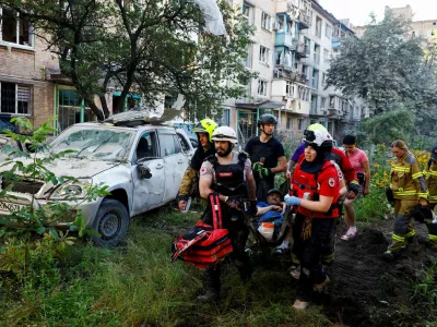 Volunteers, paramedics and rescuers carry an injured resident, at the site of an apartment building damaged during overnight Russian missile and drone strikes, amid Russia's attack on Ukraine, in Kyiv, Ukraine, July 2, 2026. REUTERS/Valentyn Ogirenko   TPX IMAGES OF THE DAY