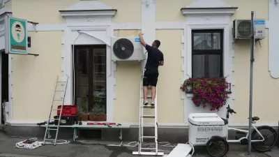 An installer sets a new air conditioning unit during a hot summer day in Belgrade, Serbia, Tuesday, June 30, 2026. (AP Photo/Darko Vojinovic)