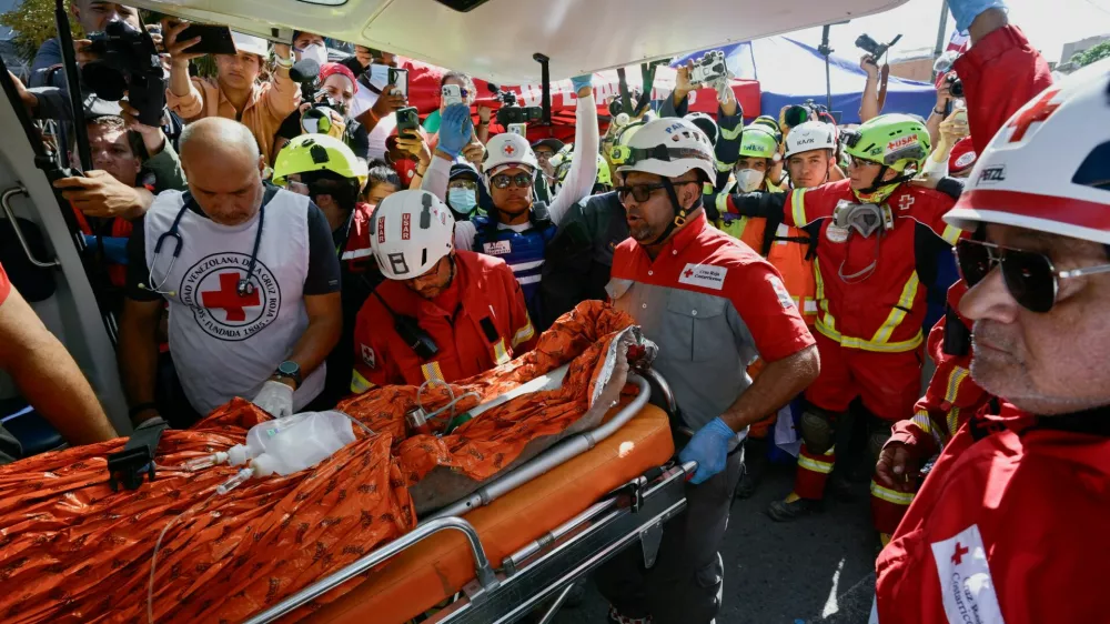 Rescue workers transport survivor Hernan Alberto Gil, who was trapped for over a week at a collapsed mall following June 24 earthquakes, in La Guaira, Venezuela, July 2, 2026. REUTERS/Maxwell Briceno