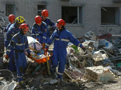 Rescuers carry the body of a killed person found under debris of an apartment building damaged during overnight Russian missile and drone strikes, amid Russia's attack on Ukraine, in Kyiv, Ukraine July 2, 2026. REUTERS/Valentyn Ogirenko   TPX IMAGES OF THE DAY