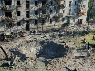 People look at the site of a Russian missile strike that hit a residential building in Kyiv, Ukraine, Thursday, July 2, 2026. (AP Photo/Efrem Lukatsky)