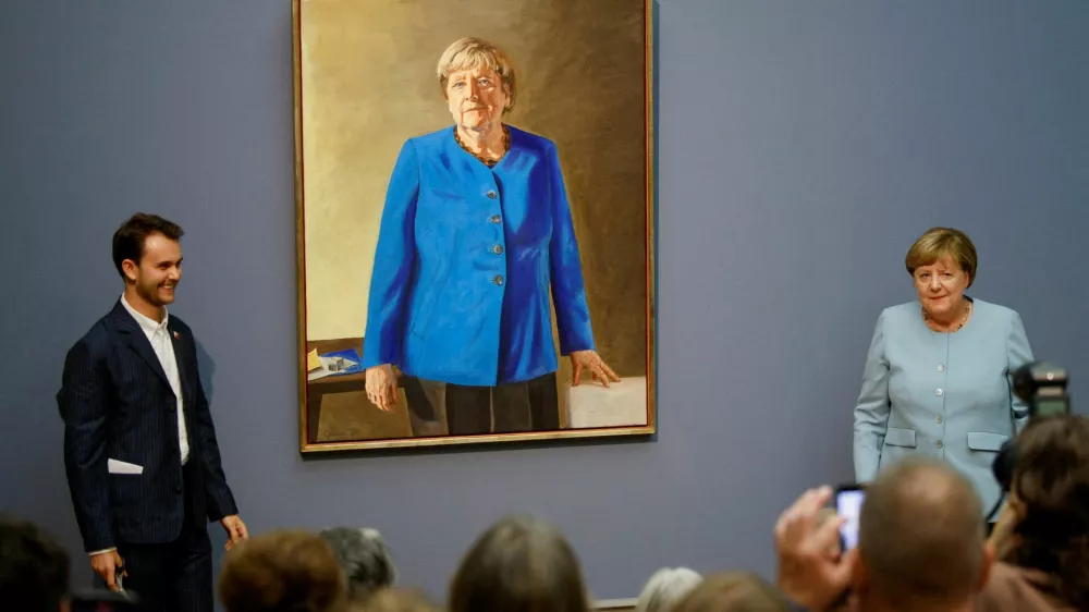 Former German Chancellor Angela Merkel stands with artist Jeremie Queyras during an event held to unveil her portrait at the Bode Museum in Berlin, Germany, June 30, 2026. REUTERS/Axel Schmidt REFILE - ADDING SPECIAL INSTRUCTIONS. FOR EDITORIAL USE ONLY - PUBLICATION IS PERMITTED SOLELY IN CONNECTION WITH COVERAGE OF THE OPENING OF THE EXHIBITION FEATURING THE PORTRAIT OF ANGELA MERKEL AT THE BODE MUSEUM, AND ONLY WITH FULL ATTRIBUTION TO THE ARTIST JEREMIE QUEYRAS.