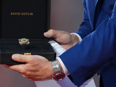 U.S. Ambassador to Belgium Bill White presents a ring designed for U.S. President Donald Trump and crafted by Antwerp diamond designer David Gotlib, during the America 250 event in Brussels, Sunday, June 28, 2026. (AP Photo/Virginia Mayo)