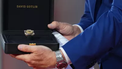 U.S. Ambassador to Belgium Bill White presents a ring designed for U.S. President Donald Trump and crafted by Antwerp diamond designer David Gotlib, during the America 250 event in Brussels, Sunday, June 28, 2026. (AP Photo/Virginia Mayo)