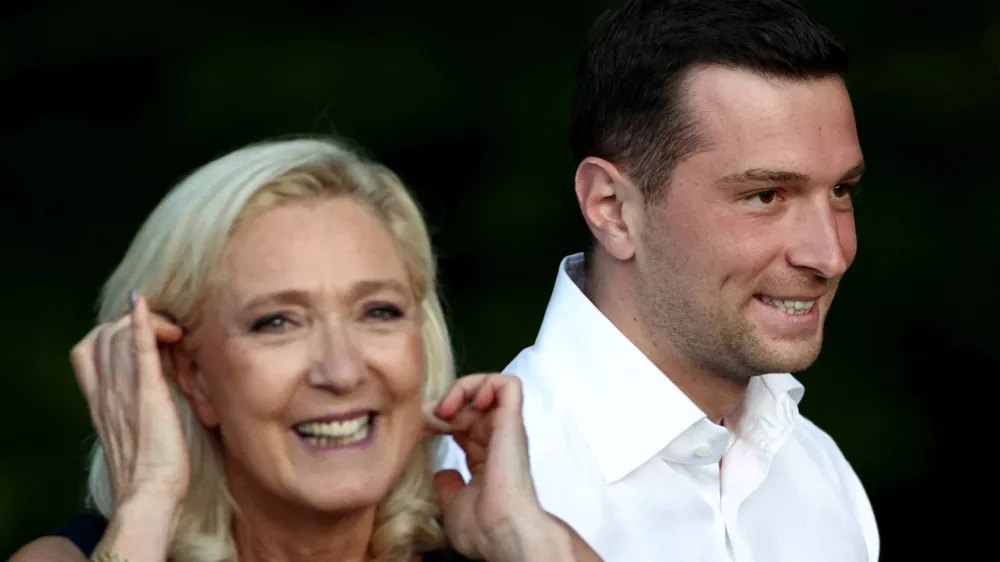 French far-right leader Marine Le Pen and Jordan Bardella, president of the French far-right Rassemblement National (National Rally - RN) political party, react after speaking at a country fair with supporters in Lievin, northern France, July 4, 2026. REUTERS/Tom Nicholson