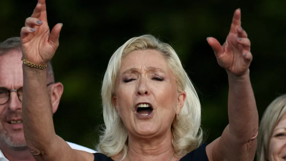 French far-right leader Marine Le Pen, member of parliament for the Rassemblement National (National Rally - RN) party, sings after delivering a speech in front of supporters during a country fair in Lievin, northern France, July 4, 2026. REUTERS/Tom Nicholson