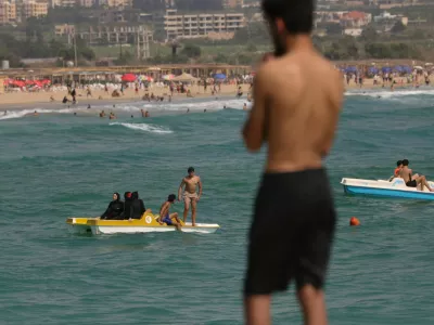 People who returned home following displacement during the war, after the Israel-Lebanon deal, relax on the beach and in the water in Tyre, southern Lebanon, July 5, 2026. REUTERS/Zohra Bensemra