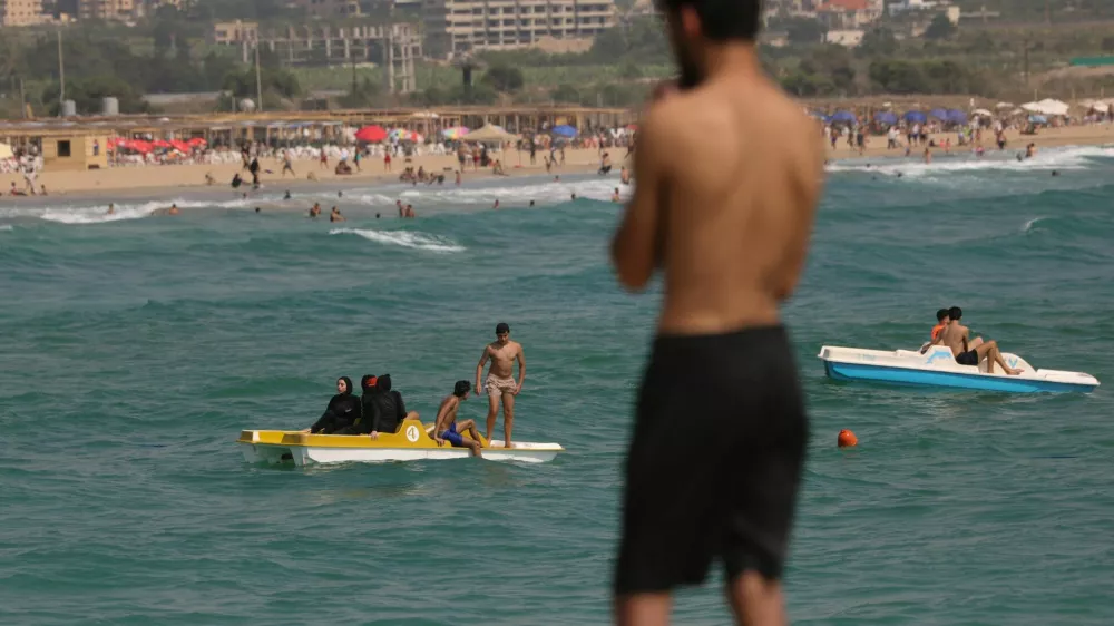 People who returned home following displacement during the war, after the Israel-Lebanon deal, relax on the beach and in the water in Tyre, southern Lebanon, July 5, 2026. REUTERS/Zohra Bensemra