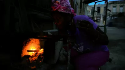 Odalys Ramos, 62, lights firewood to prepare coffee in front of her home as Cuba's national electric grid collapsed at midday, leaving around 10 million people without power, in Havana, Cuba, July 6, 2026. REUTERS/Norlys Perez