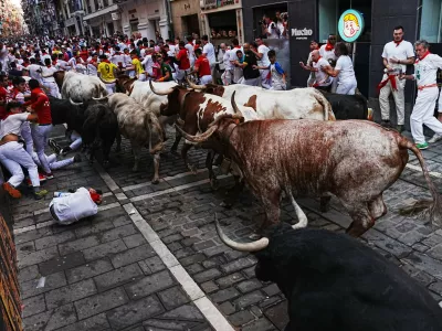 Revelers run alongside Fuente Ymbro's fighting bulls during the first running of the bulls at the San Ferm&iacute;n festival in Pamplona, Spain, Tuesday, July 7, 2026. (AP Photo/Miguel Oses)