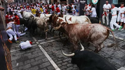 Revelers run alongside Fuente Ymbro's fighting bulls during the first running of the bulls at the San Fermín festival in Pamplona, Spain, Tuesday, July 7, 2026. (AP Photo/Miguel Oses)