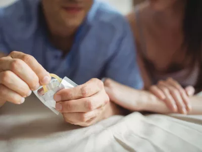 Close-up of couple with a condom on bed in the bedroom
