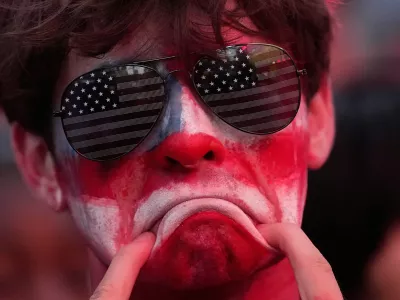 A fan reacts to a United States loss in a World Cup round of 16 soccer match against Belgium at the KC Live! entertainment district Monday, July 6, 2026, in Kansas City, Mo. (AP Photo/Charlie Riedel)