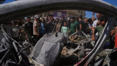 Palestinians gather around a car hit in an Israeli military strike that, according to health authorities, killed at least one person in Gaza City, Thursday, July 9, 2026. (AP Photo/Jehad Alshrafi)