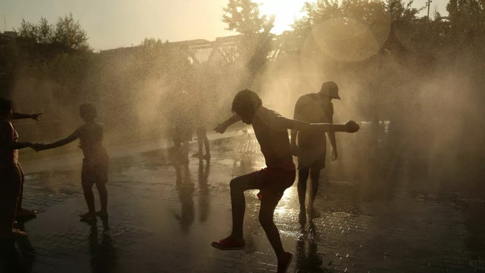 People cool off between jets of water at Madrid Rio park during a heatwave in Madrid, Spain, July 8, 2026. REUTERS/Susana Vera