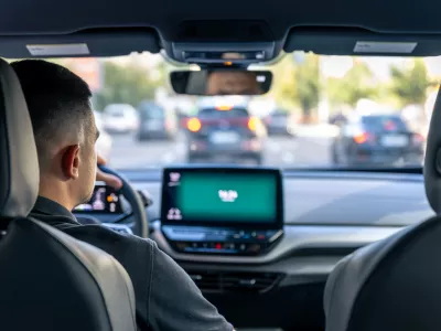 A male driver drives at speed through the streets of the city, a view from inside the car.