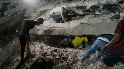 The family Nunez search for a relative in the debris of collapsed building by the earthquakes in La Guaira, Venezuela, Thursday, July 9, 2026. (AP Photo/Ariana Cubillos)