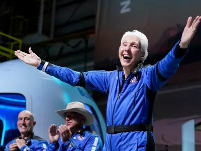 FILE - Wally Funk, right, describes her flight experience as Mark Bezos, left, and Jeff Bezos, left, center, applaud in the spaceport near Van Horn, Texas, July 20, 2021. (AP Photo/Tony Gutierrez, File)