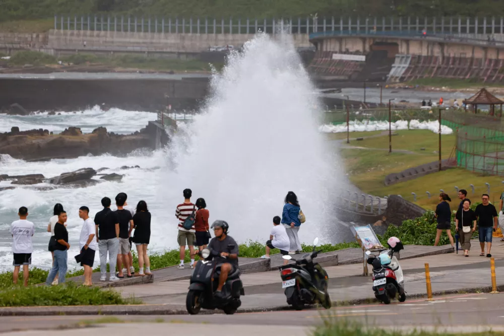 People watch waves crashing against the shoreline as Typhoon Bavi approaches in Keelung, Taiwan, July 10, 2026. REUTERS/Ann Wang