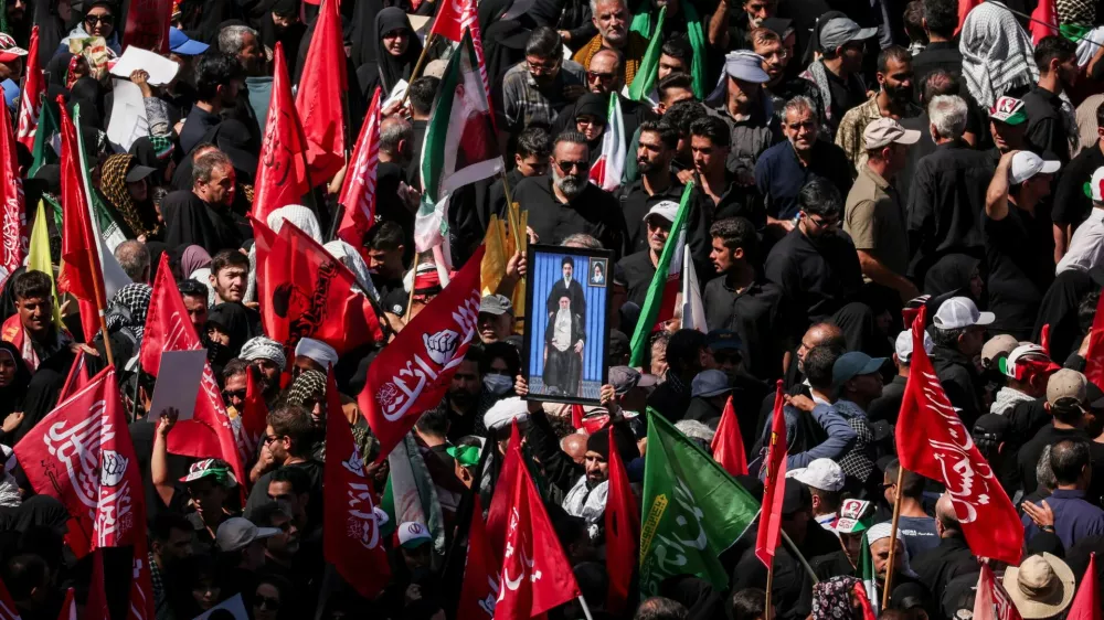 A man raises a picture featuring Iran's Supreme Leader Mojtaba Khamenei and Iran's late Supreme Leader Ayatollah Ali Khamenei, as mourners gather on the day of the burial of Ayatollah Ali Khamenei, who was killed on February 28 in Israeli and U.S. airstrikes, in Mashhad, Iran, July 9, 2026. REUTERS/Alkis Konstantinidis Foreign media in Iran operate under guidelines set by the Ministry of Culture and Islamic Guidance, which regulates press activity and permissions. ISRAEL OUT. NO COMMERCIAL OR EDITORIAL SALES IN ISRAEL. NO ACCESS FOR ISRAELI MEDIA. NO USE BBC PERSIAN. NO USE VOA PERSIAN. NO USE MANOTO. NO USE IRAN INTERNATIONAL. NO USE RADIO FARDA. DIGITAL: NO USE BBC PERSIAN. NO USE VOA PERSIAN. NO USE MANOTO. NO USE IRAN INTERNATIONAL. NO USE RADIO FARDA.