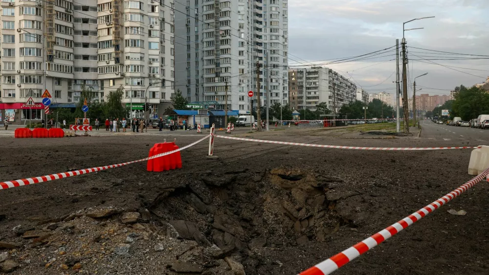 Residents gather next to a crater that appeared after Russian missile strikes, amid Russia's attack on Ukraine, in Kyiv, Ukraine July 11, 2026. REUTERS/Valentyn Ogirenko