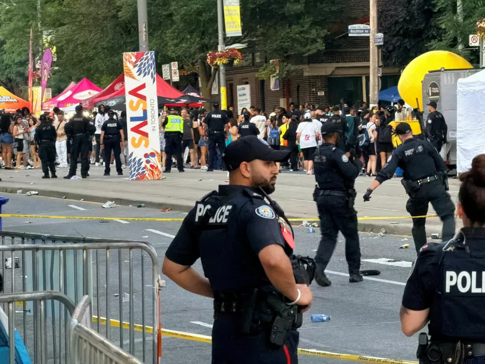 Police officers secure the scene after a deadly shooting at a salsa-themed street festival in Toronto, Ontario, Canada, July 11, 2026. Picture taken using a mobile phone. REUTERS/Cole Burston