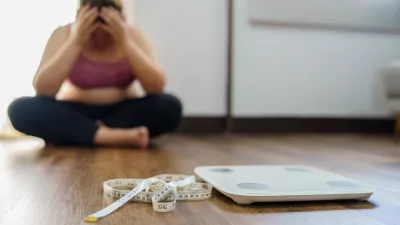 Obese Woman with fat upset bored of dieting Weight loss fail&Acirc;&nbsp; Fat diet and scale sad asian woman on weight scale at home weight control.