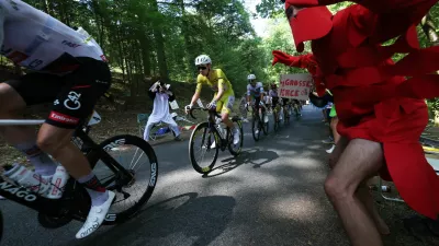 Cycling - Tour de France - Stage 9 - Malemort to Ussel - Malemort, France - July 12, 2026 UAE Team Emirates - XRG's Tadej Pogacar wearing the yellow jersey, UAE Team Emirates - XRG's Isaac Del Toro wearing the white jersey and Team Visma | Lease a Bike's Jonas Vingegaard wearing the polka-dot jersey in action as a spectator dressed in a costume cheers on during stage 9 REUTERS/Gonzalo Fuentes