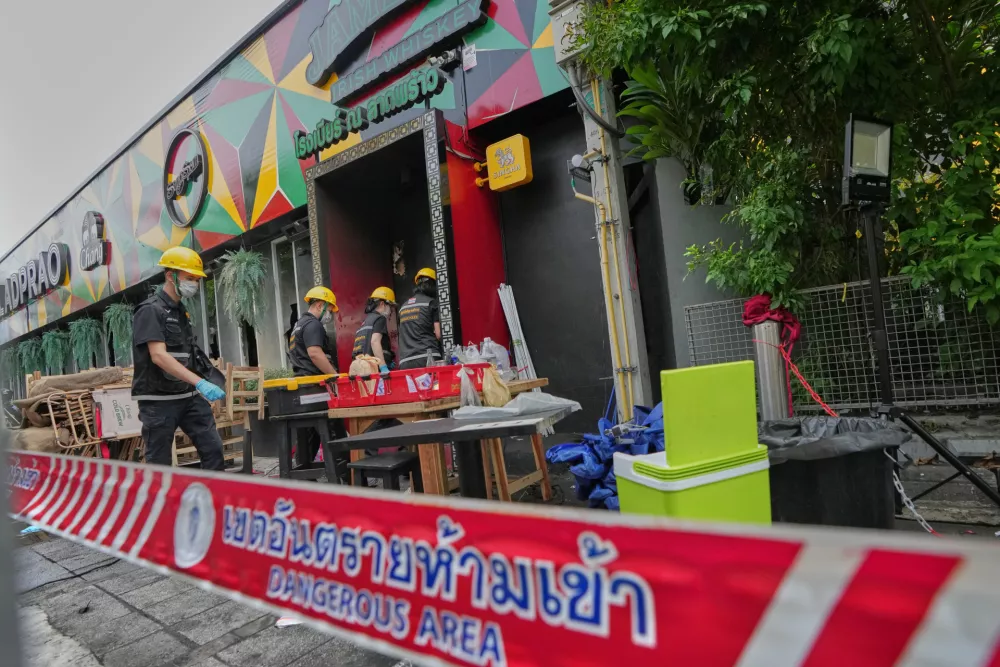 Forensic police officers inspect the site of a fire in Bangkok, Thailand, Monday, July 13, 2026. (AP Photo/Sakchai Lalit)