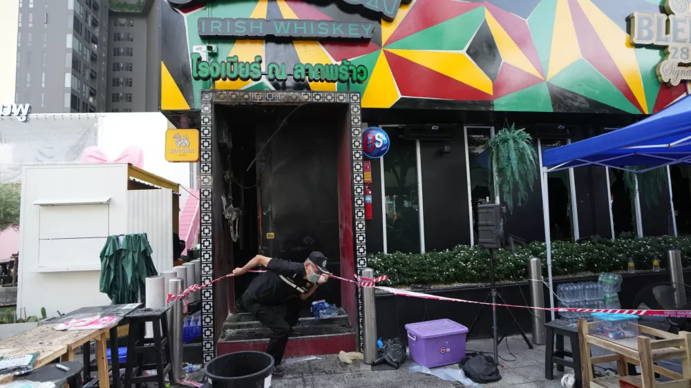 A forensic police officer leaves the site of a fire in Bangkok, Thailand, Monday, July 13, 2026. (AP Photo/Sakchai Lalit)