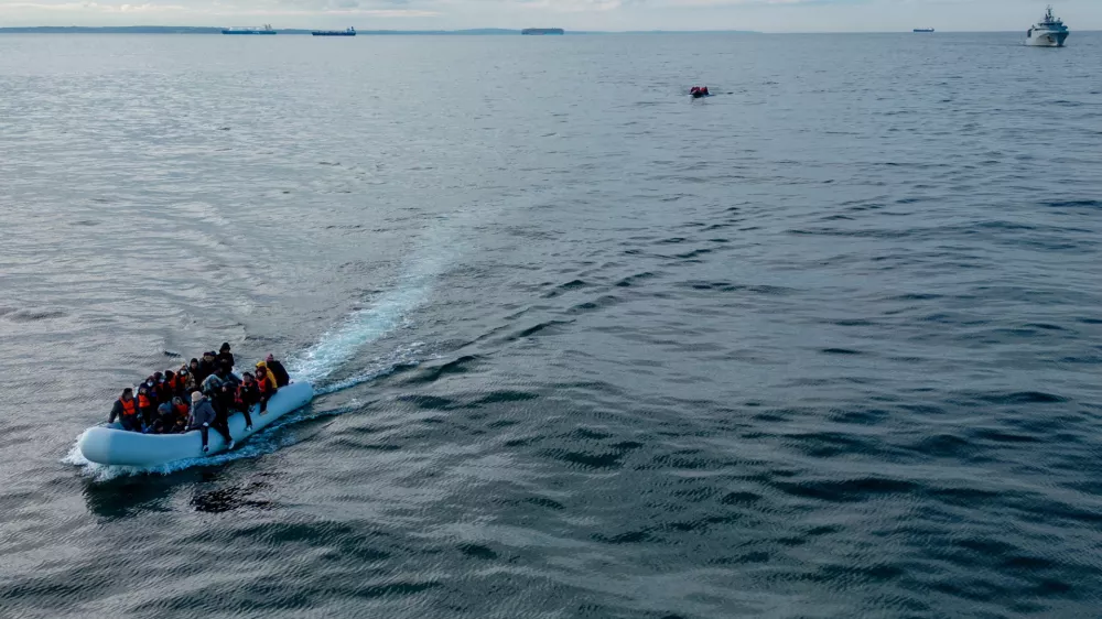 FILE PHOTO: In this drone view two inflatable dinghies carrying migrants pass a French navy vessel as they make their way towards England in the English Channel, Britain, May 4, 2024. REUTERS/Chris J. Ratcliffe/File Photo