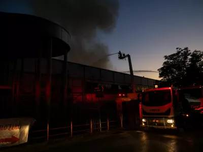Firefighters spray water from aerial platforms as smoke rises from the roof of the Badminton Theater following a fire, in Athens, Greece, July 12, 2026. REUTERS/Stelios Misinas