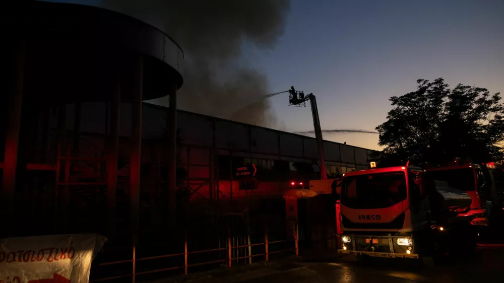 Firefighters spray water from aerial platforms as smoke rises from the roof of the Badminton Theater following a fire, in Athens, Greece, July 12, 2026. REUTERS/Stelios Misinas