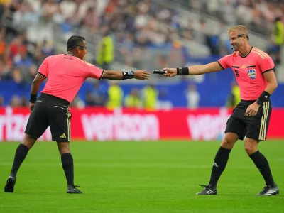 An assistant referee hands referee Ivan Barton of El Salvador the vanishing spray during a World Cup semifinal soccer match between France and Spain in Arlington, Texas, near Dallas, Tuesday, July 14, 2026. (AP Photo/Julio Cortez) / Foto: Julio Cortez