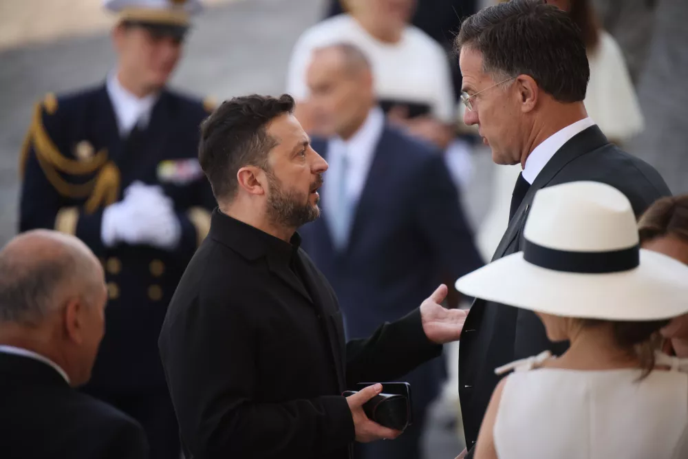 Ukraine's President Volodymyr Zelensky, center left, listens to NATO Secretary-General Mark Rutte as they arrive for the Bastille Day military parade on the Champs-Elysees avenue in Paris, Tuesday, July 14, 2026. (AP Photo/Thomas Padilla)