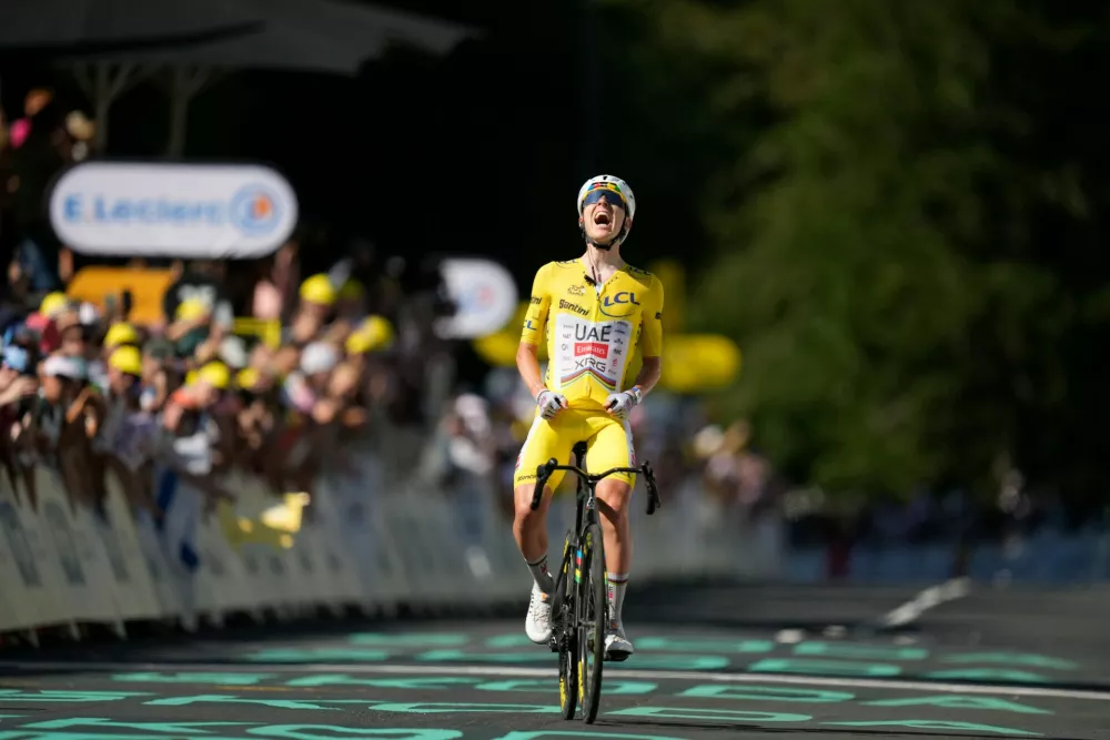 Slovenia's Tadej Pogacar, wearing the overall leader's yellow jersey, celebrates after winning the tenth stage of the Tour de France cycling race with start in Aurillac and finish in Le Lioran, France, Tuesday, July 14, 2026. (AP Photo/Mosa'ab Elshamy)